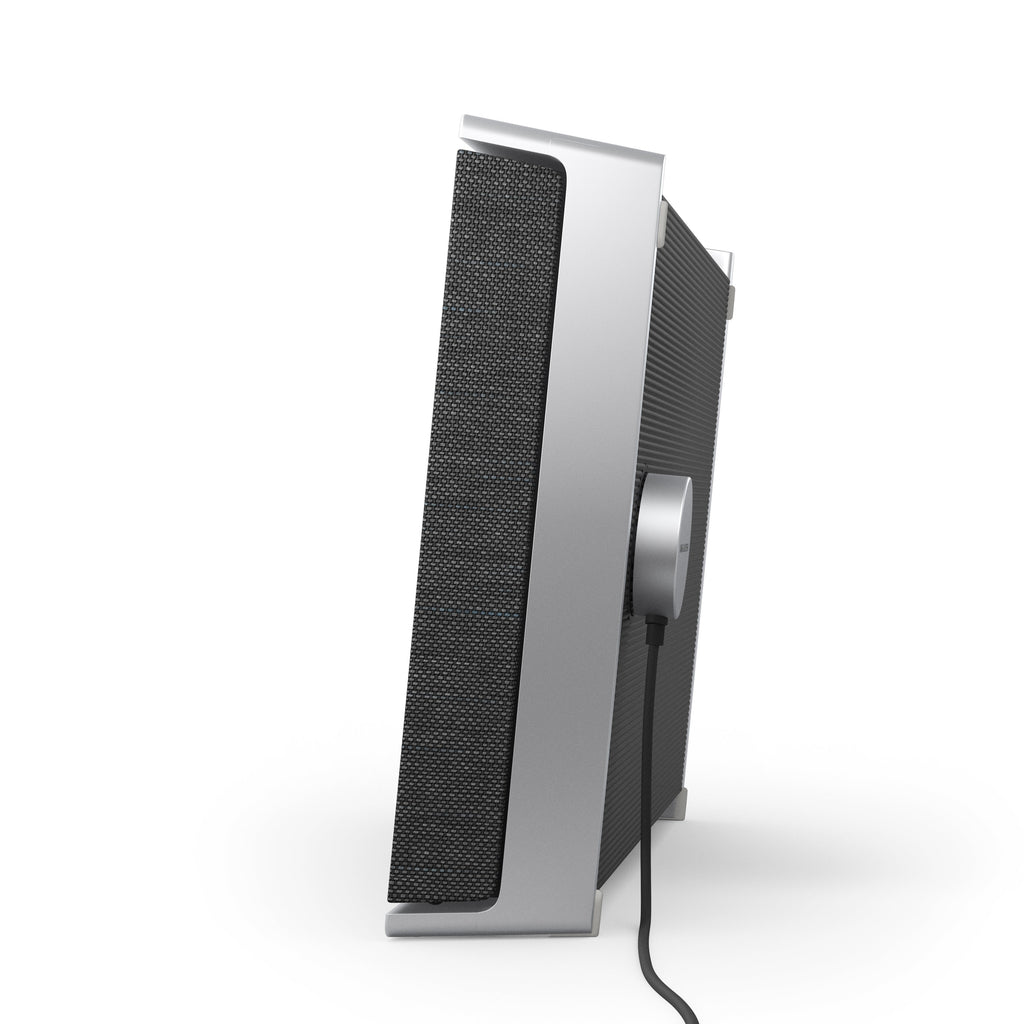 Seitenansicht des Beosound Level (Natural/Grey) im Stehen, mit angeschlossenem magnetischem Aluminium-Ladestecker und schwarzem Kabel.