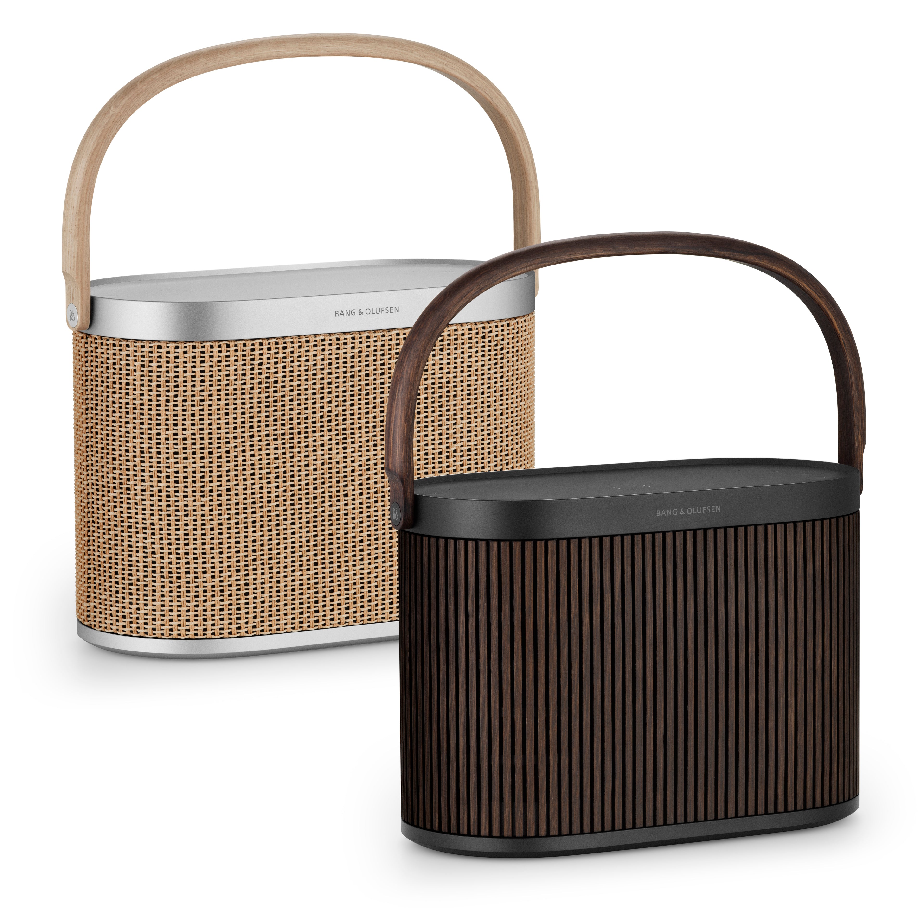 Direkter Vergleich zweier Bang & Olufsen Beosound A5 Lautsprecher: Im Hintergrund die helle Variante „Nordic Weave“ mit Papiergeflecht und heller Eiche, im Vordergrund die Variante „Dark Oak“ mit dunklen Echtholz-Lamellen und schwarzem Aluminium.
