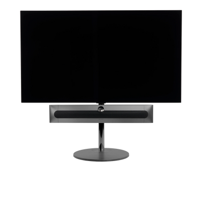 Beosound Premiere in black anthracite auf Bodenstandfuß von stb brackets,  mit Stoff- Abdeckung in Grey Mélange vorn, mit 65  Zoll LG OLED Panel - Ansicht frontal 