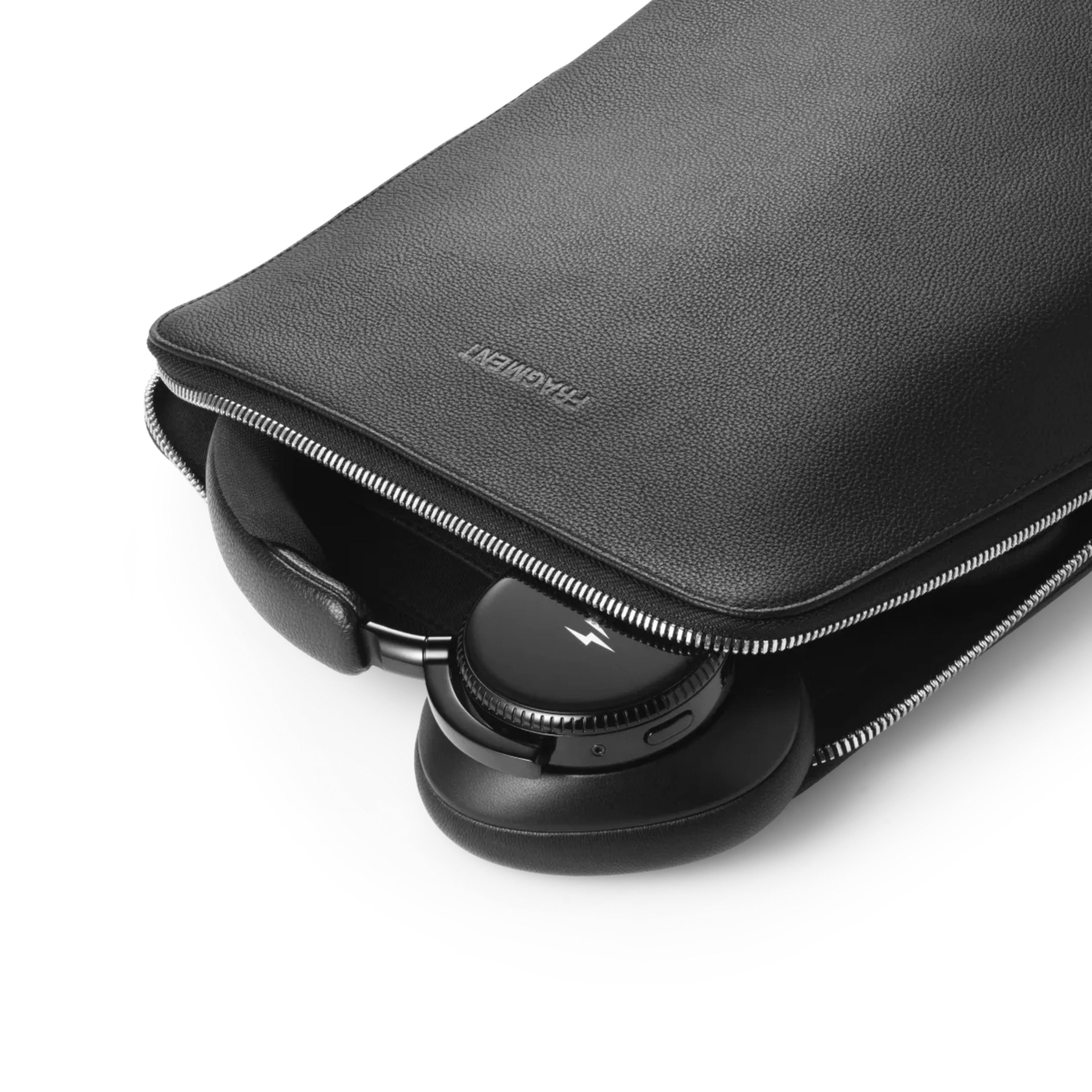 Schrägansicht des freigestellten Bang & Olufsen Beoplay H100 fragment edition Kopfhörers beim Verstauen im exklusiven Echtledercase. Das luxuriöse All-Black-Reiseset mit High-Res-Audio und geprägter FRAGMENT-Schutztasche bietet ultimativen Schutz und Stil für anspruchsvolle Sammler.
