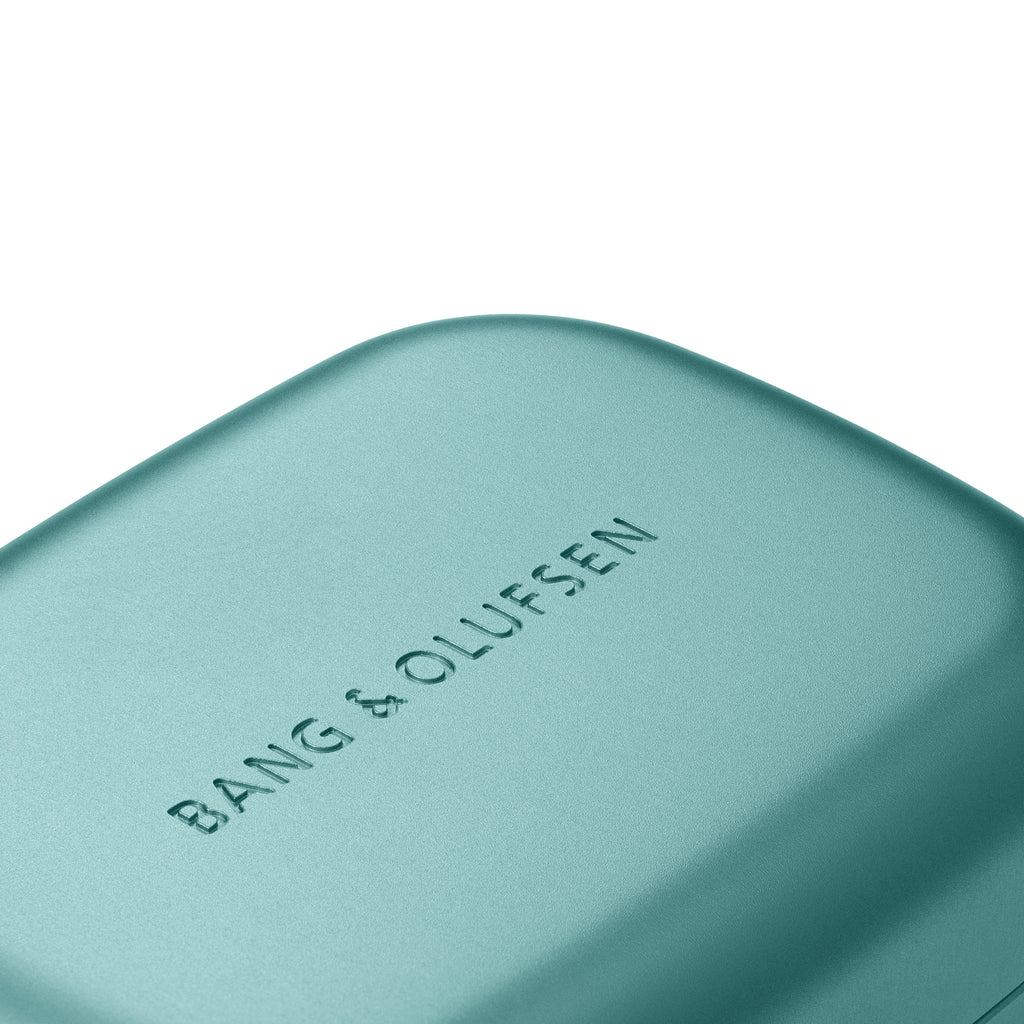 Bang & Olufsen, B&O, Beoplay Eleven (Hi-Fi-ANC-Earbuds) - Ladeschale in Eucalyptus Green - Detailaufnahme Bang & Olufsen schriftzug