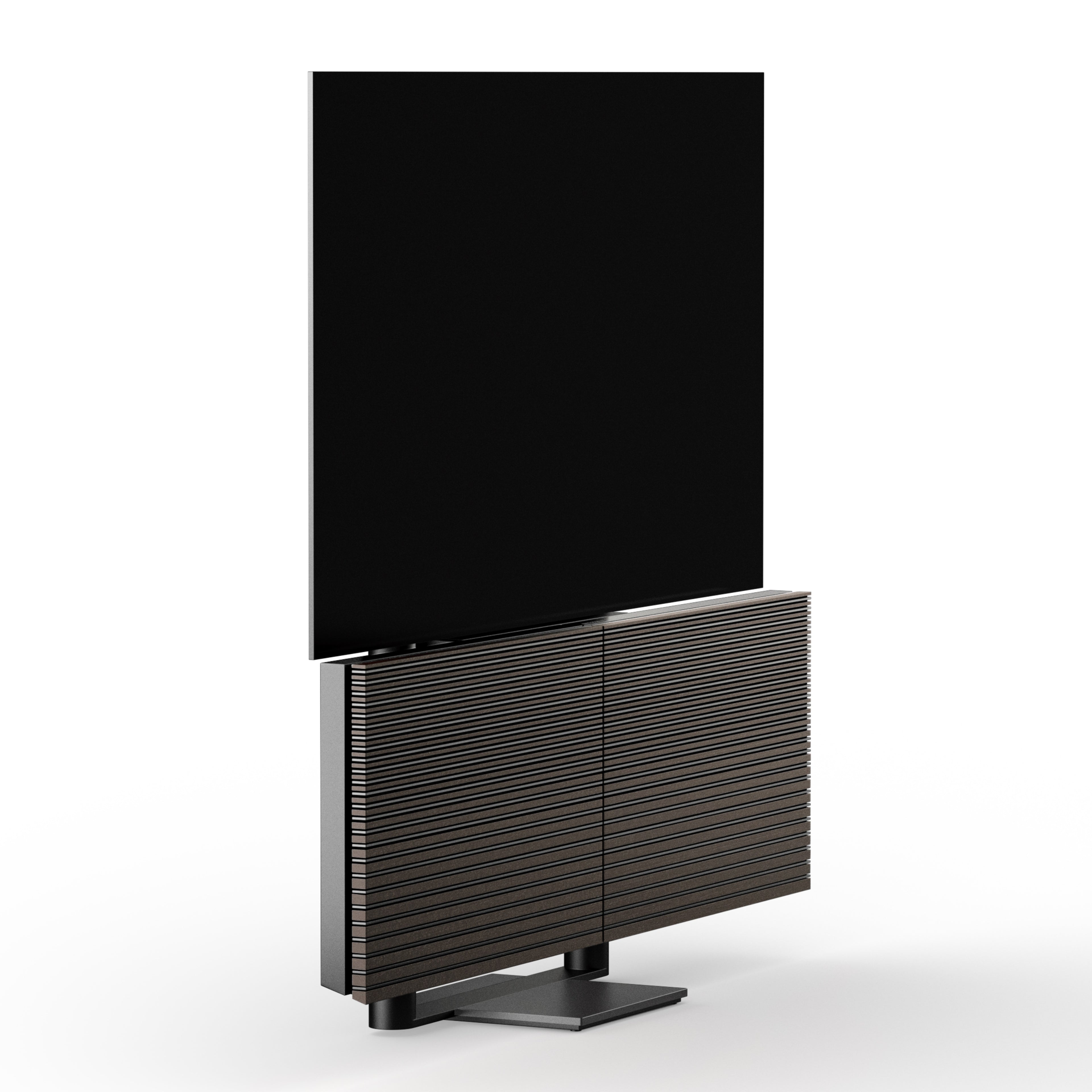 Studio-Aufnahme des Bang & Olufsen Beovision Harmony TV in der entfalteten Position. Das Bild zeigt den angehobenen OLED-Bildschirm und die horizontal ausgerichteten Lautsprecher-Abdeckungen aus dunkler Eiche (Dark Oak) auf einem minimalistischen Bodenstandfuß vor weißem Hintergrund.
